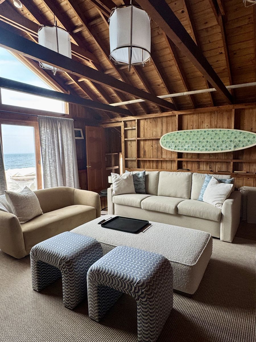 Living room after renovation — restyled seating under the original wood ceiling
