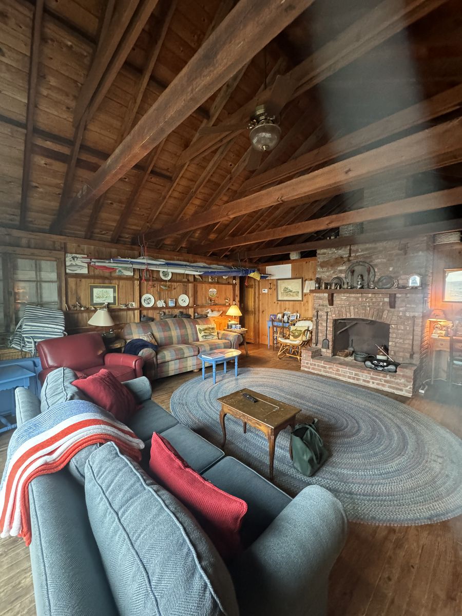 Living room before renovation — exposed rafters and dated furnishings